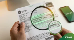 Como ler sua conta de luz com desconto. Uma mão segura uma conta de luz da EDP Escelsa no Espírito Santo com uma lupa digital apontando para campos específicos de "Energia Injetada" e "Desconto Solar iGreen". O fundo mostra um escritório moderno com o logo iGreen.